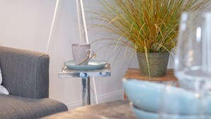 Ein Essbereich mit Tisch für zwei Personen, einer Lampe und einem Blumentopf.