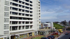 Ein mehrstöckiges Hotel mit modernem architektonischen Design, das eine Reihe von Balkonen und großen Fenstern aufweist.