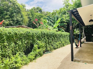 Relax in a serene garden setting with a hammock and covered seating area.