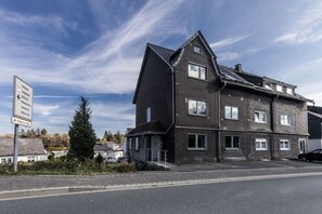 Ein mehrstöckiges Gebäude mit dunkler Fassade und zahlreichen Fenstern.