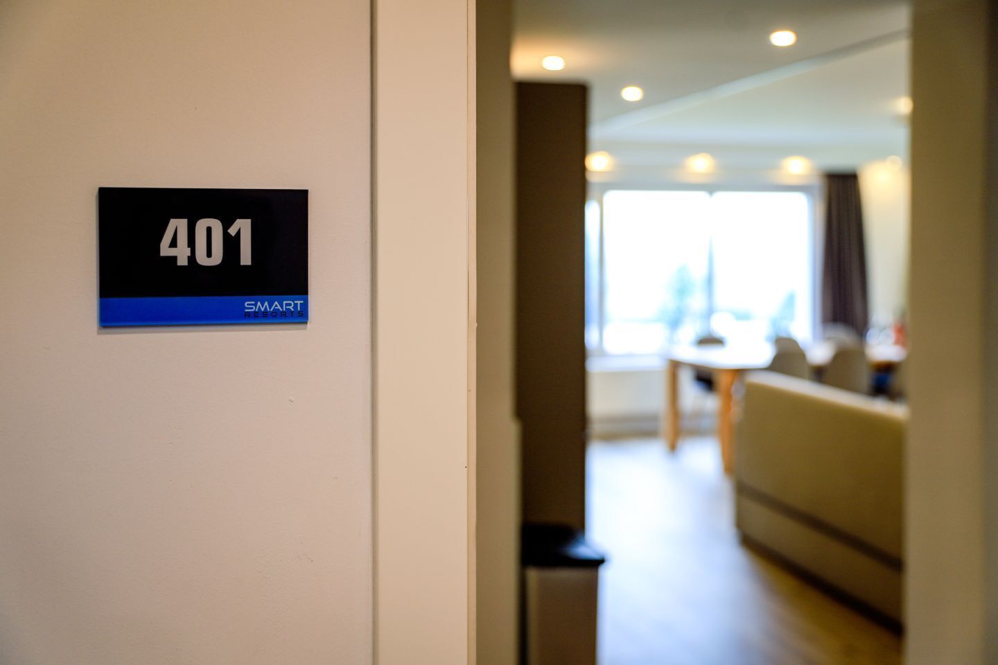 A hotel room with a sign indicating room number 401 and the name 'SMART RESORTS'.