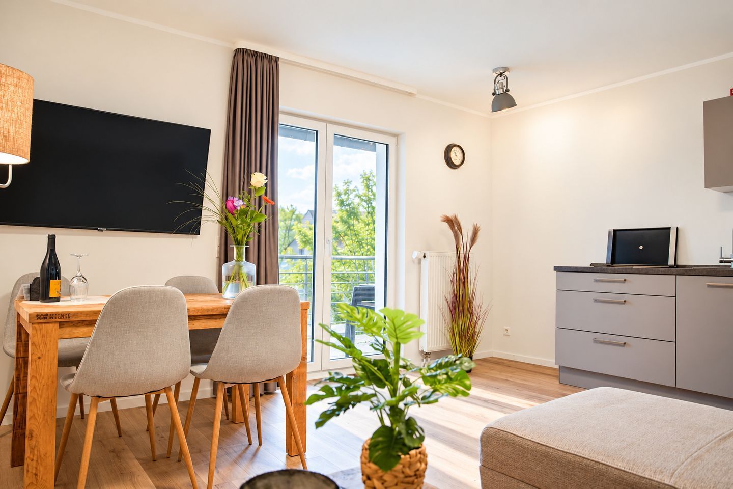 Un espace de vie moderne comprenant un coin repas, une cuisine et un balcon avec vue.