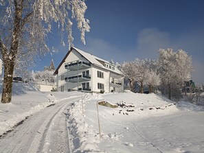 A two-story house with a balcony, surrounded by snow-covered trees and a clear sky. - Smart Resorts - Opal House - Apartment 402 with 1 bedroom and a balcony, (Winterberg)