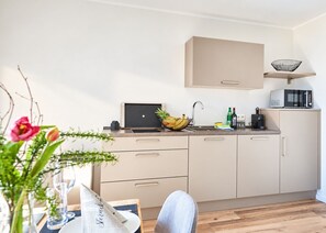 A modern kitchen with a laptop, a fruit bowl, a coffee maker, and a microwave. - Smart Resorts - Opal House - Apartment 402 with 1 bedroom and a balcony, (Winterberg)