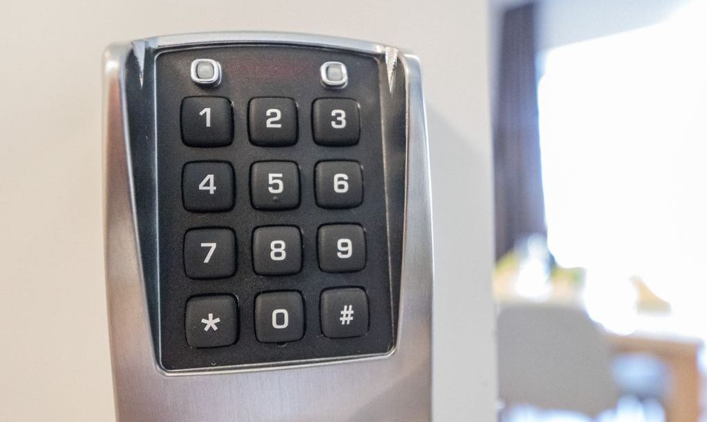 Ein Detailaufnahme einer Zahlentastatur auf einem metallischen Gerät, vermutlich einer Bedienungsplatte im Hotelzimmer.
