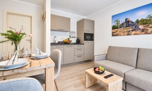 Un espacio moderno de estar con comedor, cocina y sofá.