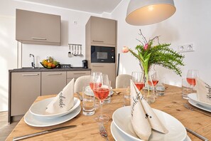 Une table à manger dressée avec des assiettes, des verres et un vase rempli de fleurs.