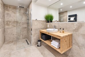 A modern bathroom with a glass-enclosed shower, a wooden vanity with a sink, and a mirror above. - Smart Resorts - Haus Azur - Ferienwohnung 809, Max. 4 Personen - Smart Resorts Haus Azur (Winterberg)