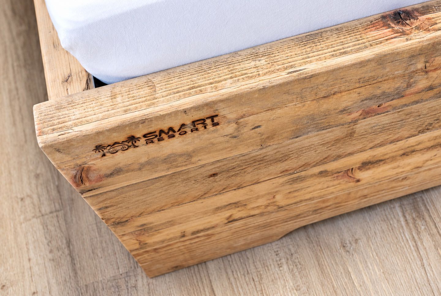 Estructura de cama de madera con la inscripción 'SMART RESORTS'.