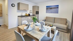 Ein modernes Apartment mit Essbereich, Küchenzeile und einer Couch.