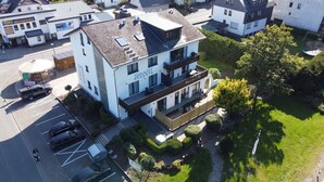 Ein modernes, zweistöckiges Gebäude mit einem Balkon im zweiten Stock, beschriftet mit 