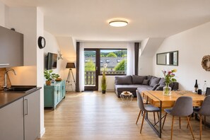 Un appartement moderne comprenant une cuisine, un coin repas et un salon.