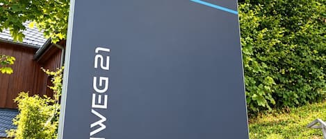A sign for Smart Resorts Haus Brilliant with the name Buchenweg 21.