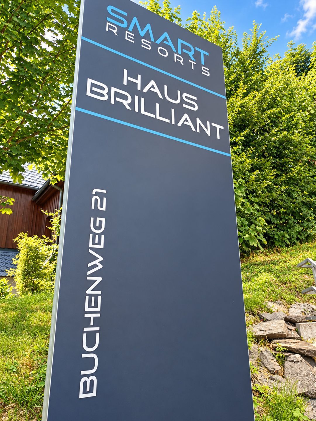 A sign for Smart Resorts Haus Brilliant with the name Buchenweg 21.