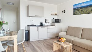 Eine moderne Wohnung mit Küchenzeile, Essbereich und Wohnzimmer.