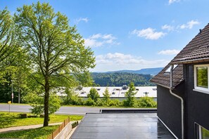 A residential building with a balcony overlooking a road and a forested area. - Smart Resorts - Haus Saphir - Ferienwohnung 508 mit 2 Schlafzimmern, Max. 6 Personen - Smart Resorts (Winterberg)