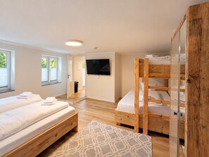 Une chambre moderne avec un lit superposé, un téléviseur à écran plat et une grande fenêtre.