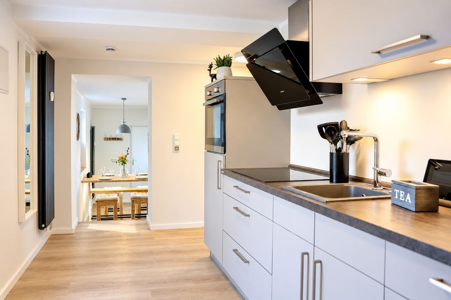 A modern kitchen with a central island, stainless steel appliances, and a built-in oven.