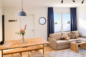 Ein modernes Wohnzimmer mit einem Holzesstisch, einer Couch und einem Couchtisch.