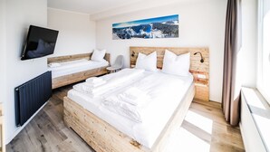 A hotel room with two beds, a TV, a painting, and a window. - Smart Resorts - House Diamant - Apartment 705 with balcony, max. 5 persons - (Winterberg)