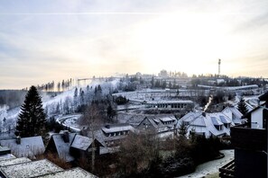 A winter scene with a railway station, snow-covered buildings, and a forested area. - Smart Resorts - House Diamant - Apartment 705 with balcony, max. 5 persons - (Winterberg)