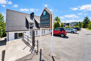 A building with a sign for 'SMART RESORTS WINTERBERG' and a parking area with cars. - Smart Resorts - Haus Diamant - Studio-apartment 708 mit Balkon, Max. 4 Personen - Smart Resorts Haus (Winterberg)