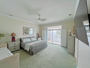 A bedroom with a bed, nightstands, a ceiling fan, and a large window. - 🏖️Beachfront🏖️ Forget your worries in this spacious and serene space ♡ (Alligator Point)