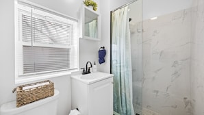 Une salle de bain moderne équipée de toilettes, d’un lavabo et d’une douche.