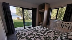 Un dormitorio con cama, armario y vistas a un jardín.