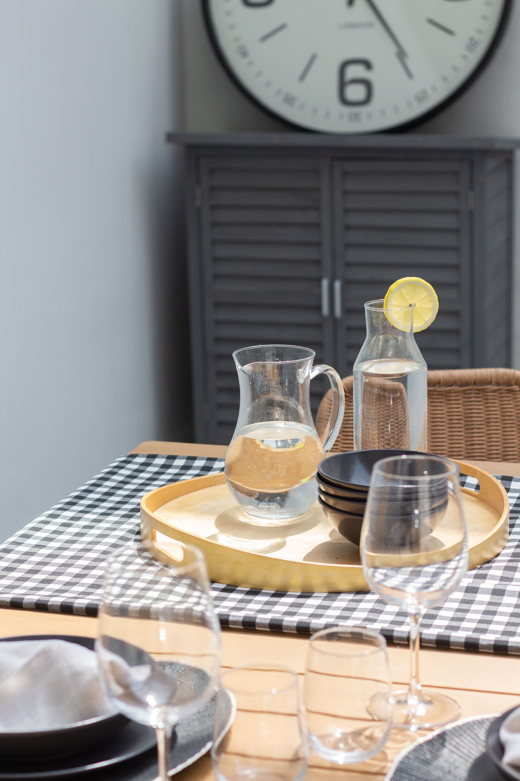 A table set with a pitcher, glasses, and a tray.