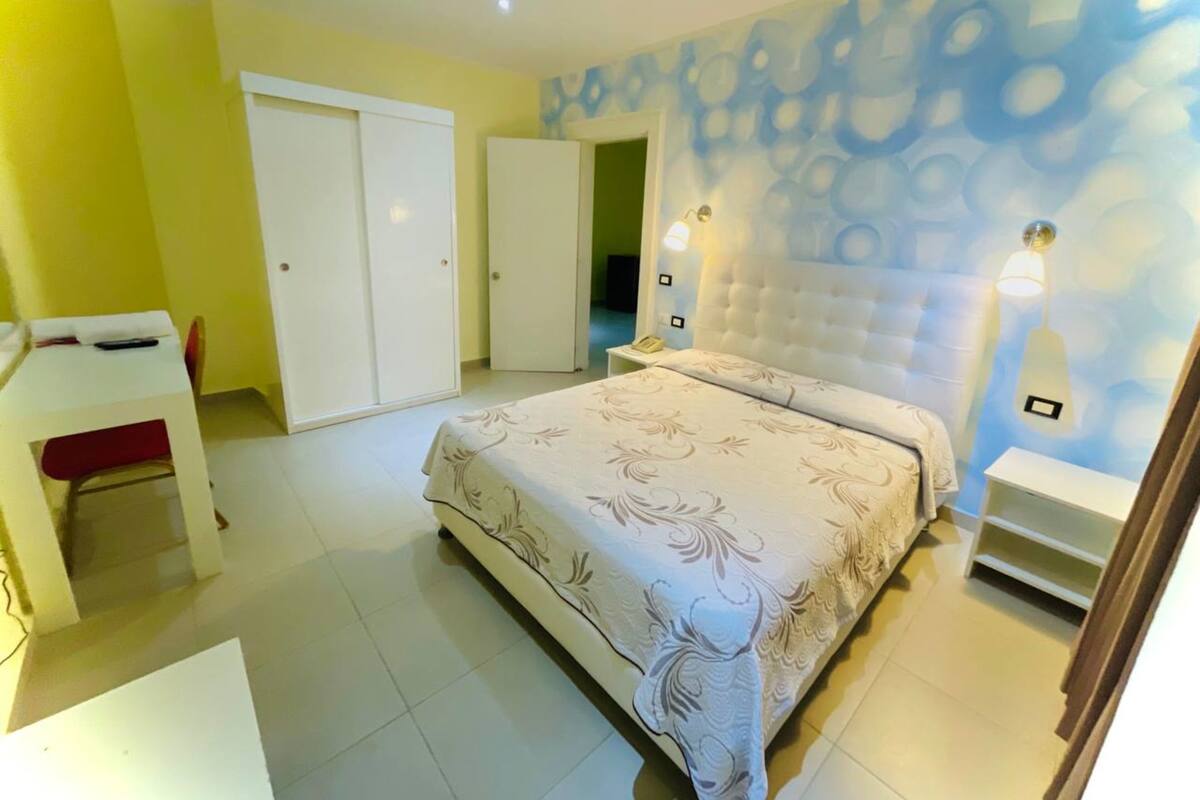 Een slaapkamer met een bed, bureau en kledingkast.