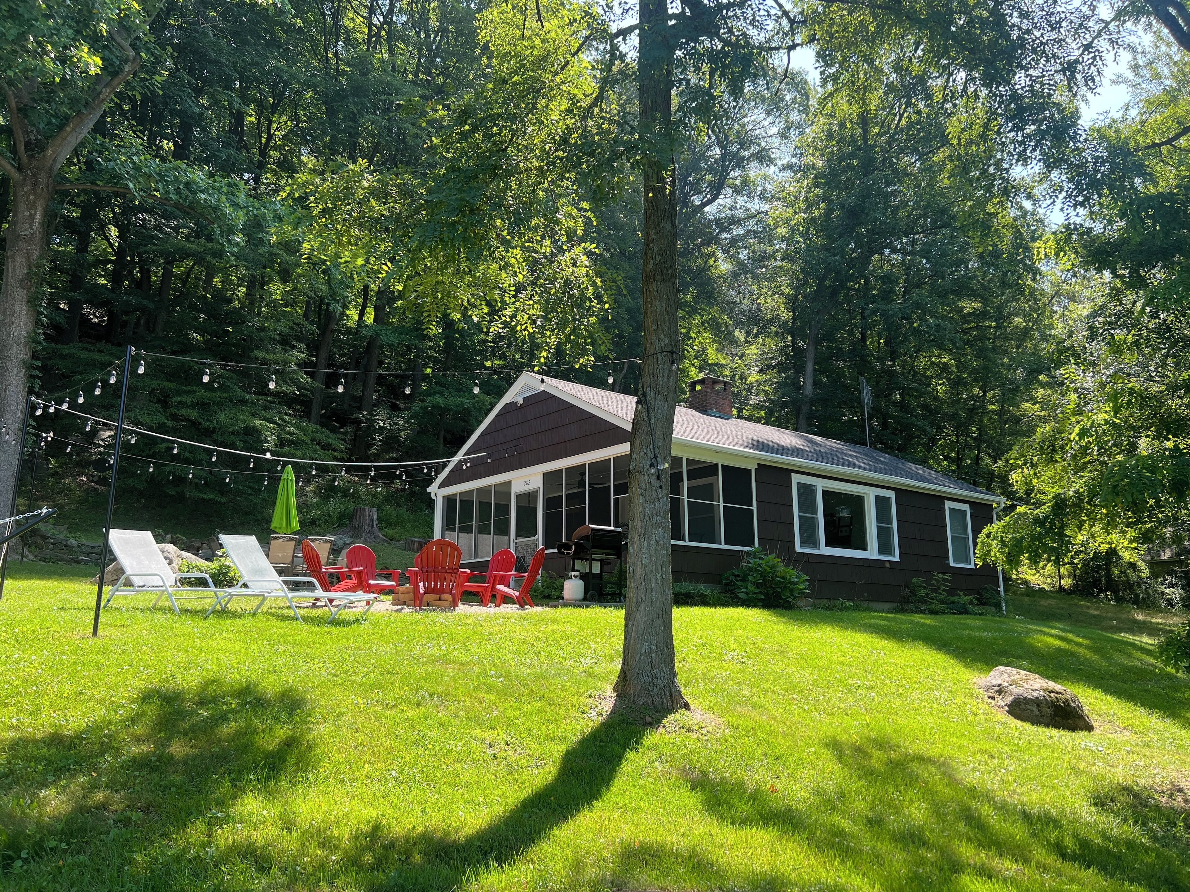 A house with a porch, red chairs, and string lights.