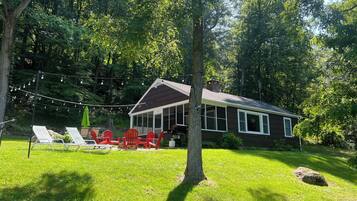 A house with a porch, red chairs, and string lights.