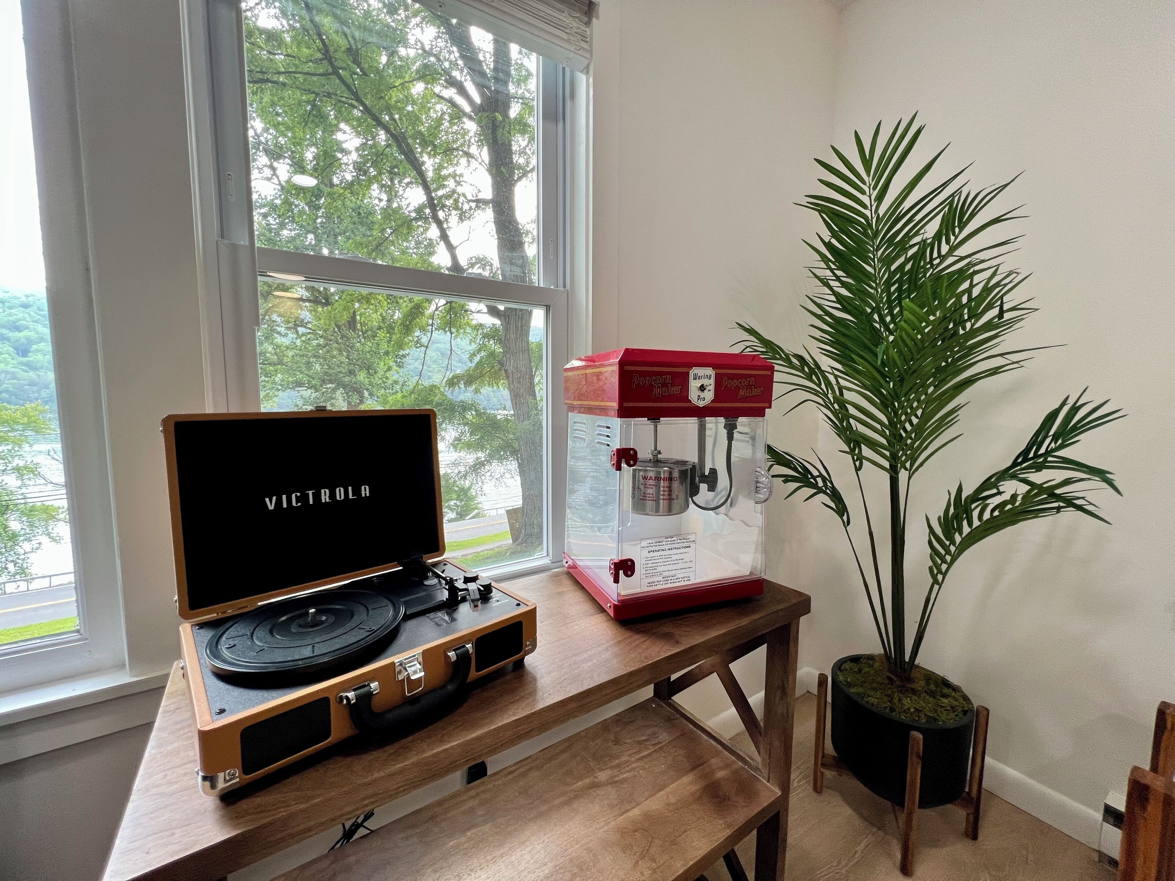A wooden table with a turntable and a popcorn maker.