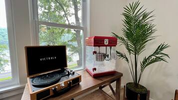 A wooden table with a turntable and a popcorn maker.