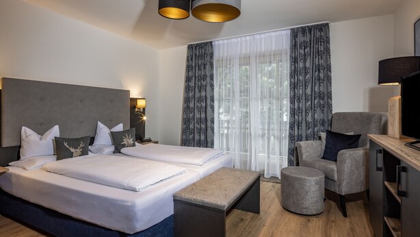 Ein modernes Hotelzimmer mit einem großen Bett, einem Schreibtisch und einem Stuhl.