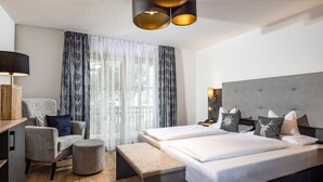 Una habitación de hotel moderna con una cama grande, una silla, un escritorio y una lámpara.
