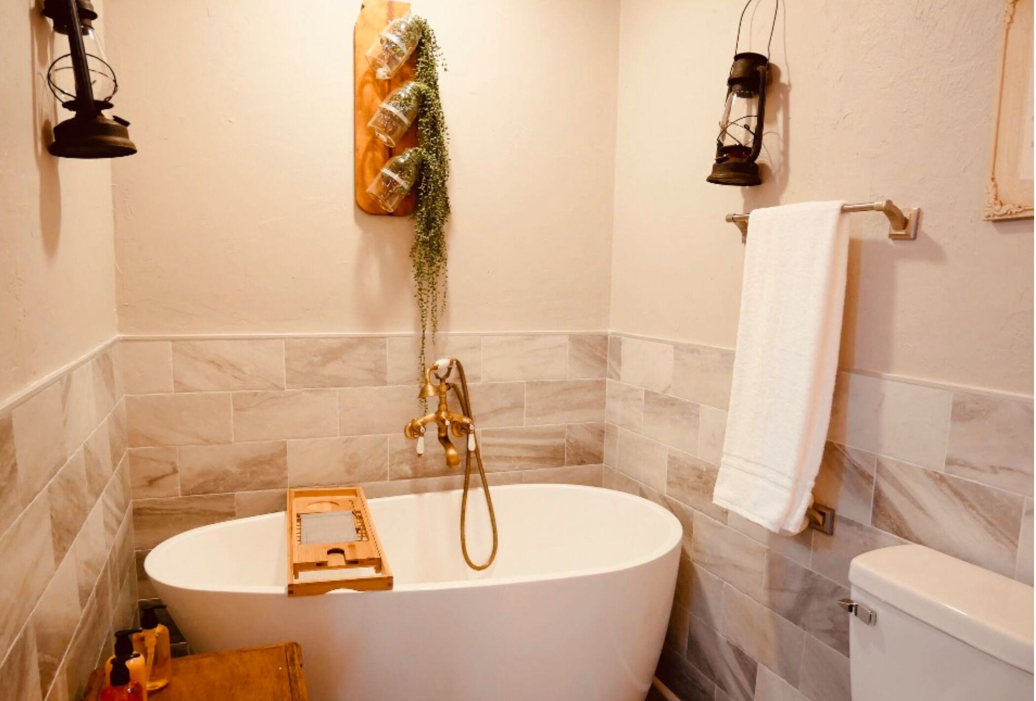 A bathroom with a freestanding bathtub, a toilet, and a towel rack.