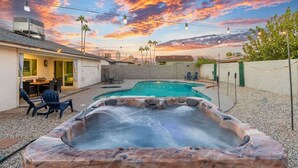 A backyard with a hot tub, a pool, and a patio area with chairs. - Cozy 3BR Stadium Oasis! Pool + Hot Tub + Fire Pit (Glendale)