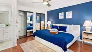 A bedroom with a bed, bedside tables, a ceiling fan, and a large window. - Cozy 3BR Stadium Oasis! Pool + Hot Tub + Fire Pit (Glendale)