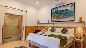 Una camera da letto con un letto in legno, un quadro raffigurante un tempio e uno spazio doccia.