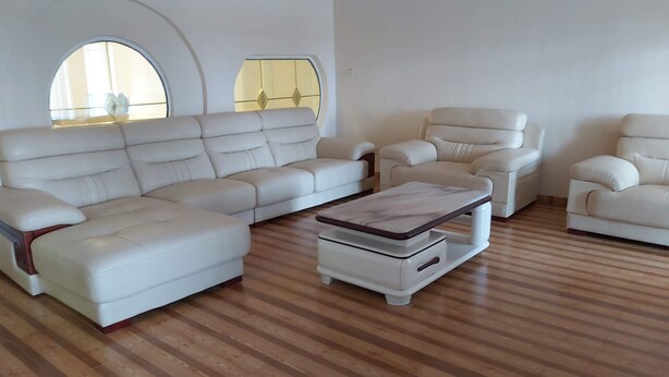 A spacious living room with a sectional sofa, a chaise lounge, and a coffee table. - Villa Sleeps 10 with Garden (DR Congo)