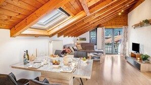 Un espace de vie moderne de style loft, comprenant un coin repas, un canapé et un téléviseur.