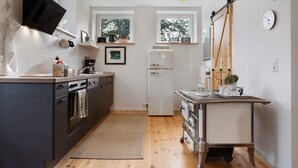 Eine moderne Küche mit Einbauofen, Kühlschrank und Essbereich mit Tisch und Stühlen.