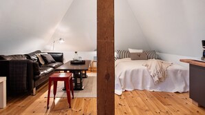 Un dormitorio estilo loft acogedor con cama, una mesita y un sofá.