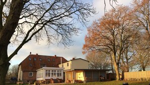 A two-story house with a brick facade, a white front porch, and a garage.