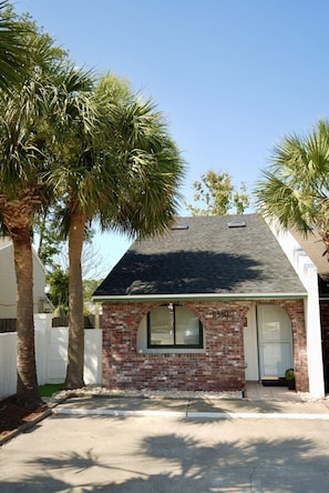 A single-story house with a brick facade, a dark roof, and a small front porch. - Grand Lagoon Vista -air hockey- Dreamy Day (Panama City Beach)