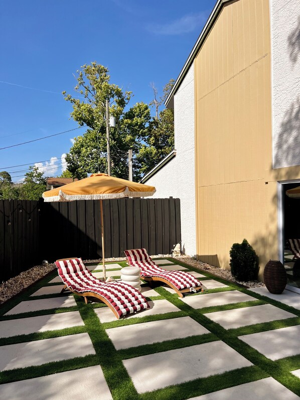 A backyard with two lounge chairs and a yellow umbrella. - Grand Lagoon Vista -air hockey- Dreamy Day (Panama City Beach)