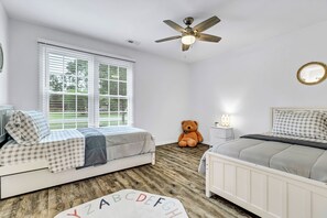 A bedroom with two beds, a ceiling fan, a large window, and a teddy bear. - Quiet escape in Wilmington (Wilmington)