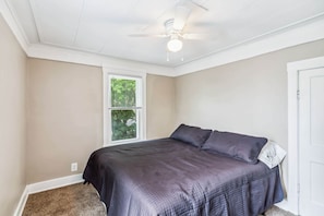 A bedroom with a bed, a ceiling fan, a window, and a door. - Furnished housing near Lima for workers (Lima)